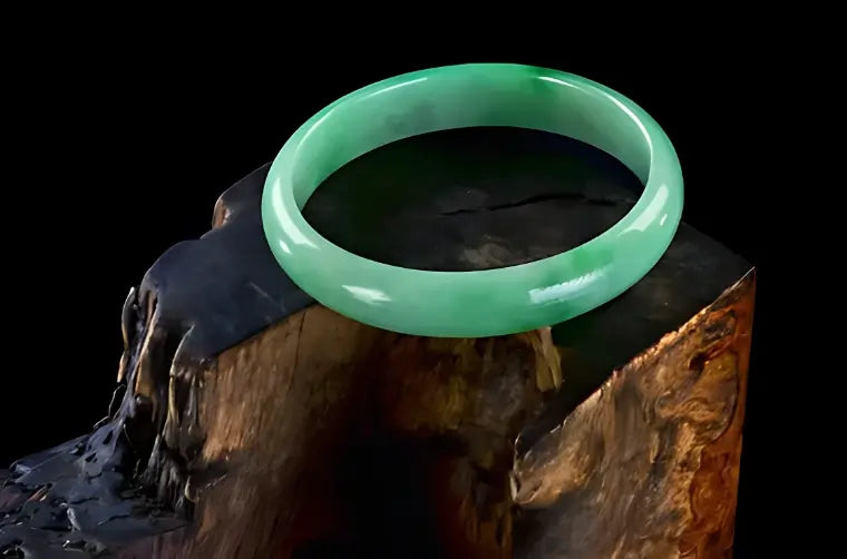 Polished green jade bangle displayed on textured wood, symbolising harmony, longevity and spiritual protection in traditional Chinese culture.